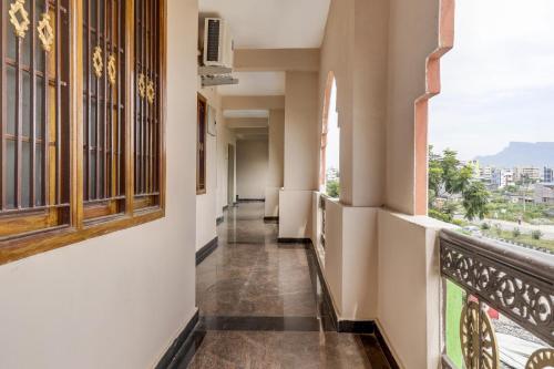 um corredor de um edifício com janelas e uma varanda em Super OYO V M Inn em Tirupati
