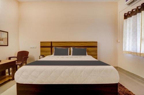 um quarto com uma cama grande e uma cabeceira em madeira em Super OYO V M Inn em Tirupati