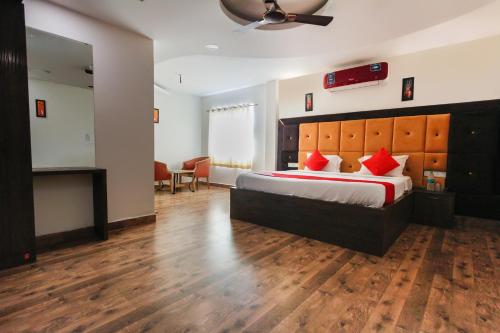 um quarto com uma cama grande e almofadas vermelhas em OYO Grand Beach Palace em Tirupporūr
