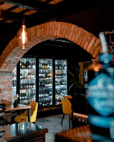 a restaurant with a bar with shelves of wine bottles at Bužinel Estate in Dobrovo