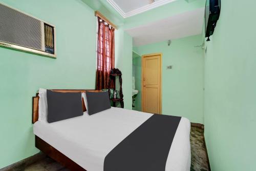 a bedroom with a white and black bed and a window at OYO Rainbow Stays in Tiruchirappalli
