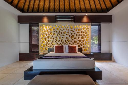 a bedroom with a bed and a large wall at Villa Samudra Raya in Seminyak