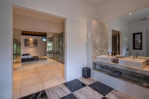 a bathroom with two sinks and a living room at Villa Samudra Raya in Seminyak