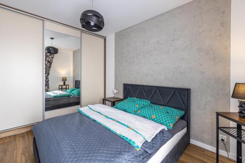 um quarto com uma cama e um espelho grande em Apartament 32 em Gąski
