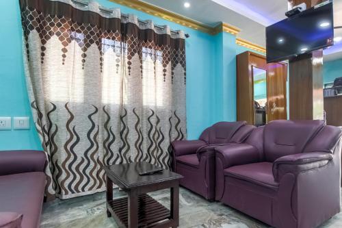 a living room with purple couches and a table at Collection O Hotel Jaisas Paradise in Agastīswaram