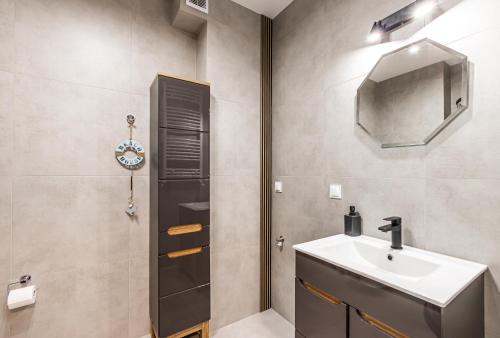 a bathroom with a sink and a mirror at Apartament 32 in Gąski