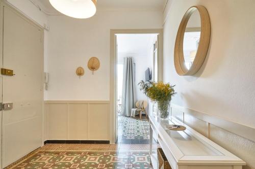 a hallway with a table and a mirror at BBarcelona Sagrada Familia Garden Apartment in Barcelona