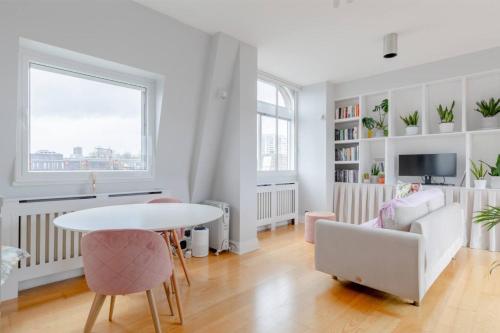 a white living room with a table and a couch at Lavish 1BD Flat Heart of London Marylebone! in London