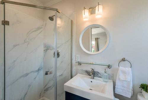 a bathroom with a shower and a sink and a mirror at Quite Spacious, Hot Tub Near Montecito, EV Charger in Santa Barbara