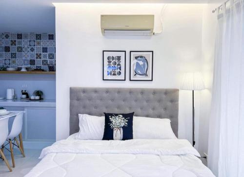 sypialnia z białym łóżkiem z szarym zagłówkiem w obiekcie Moonlight House Tagaytay w mieście Tagaytay