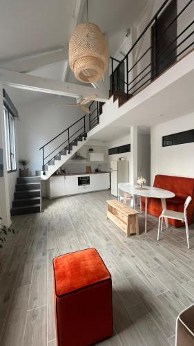 een woonkamer met een tafel, stoelen en een trap bij ÂU-LAC loft rénové en 2024 in Lourdes