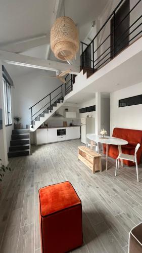 ein Wohnzimmer mit einem Tisch, Stühlen und einer Treppe in der Unterkunft ÂU-LAC loft rénové en 2024 in Lourdes