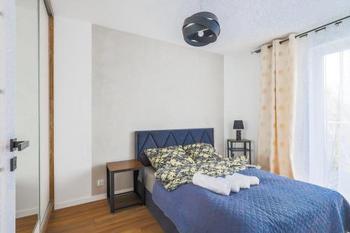 Un dormitorio con una cama azul con toallas. en Apartament 33 en Gąski