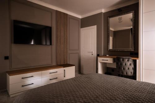 a bedroom with a bed with a dresser and a mirror at Sobor Family Resort in Stavcheny