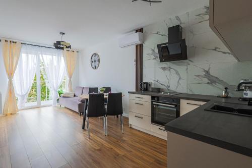 cocina y sala de estar con mesa y sillas en Apartament 33 en Gąski