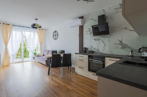 a kitchen and living room with a table and chairs at Apartament 33 in Gąski