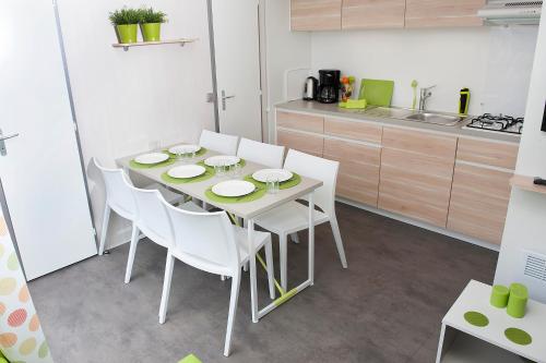 a kitchen with a white table and white chairs at Happy Lodge in Alphen