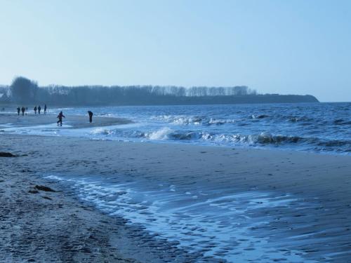 a beach with people playing in the water at Modern Holiday Home in Brusow with Roofed Terrace in Kröpelin