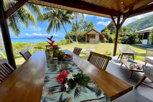 a wooden table with flowers on it on a patio at Pae Miti Beach house - white sand beach - Tahiti - 7 people in Punaauia