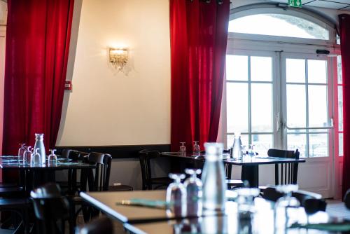 uma sala de jantar com mesas e cortinas vermelhas em Villages Clubs du Soleil - SUPERBAGNERES em Superbagnères