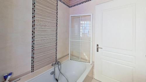 une salle de bain avec une baignoire et une fenêtre dans l'établissement EXIGEHOME - Maison à 2 pas de la foret - 10 min de Versailles, à Vélizy-Villacoublay