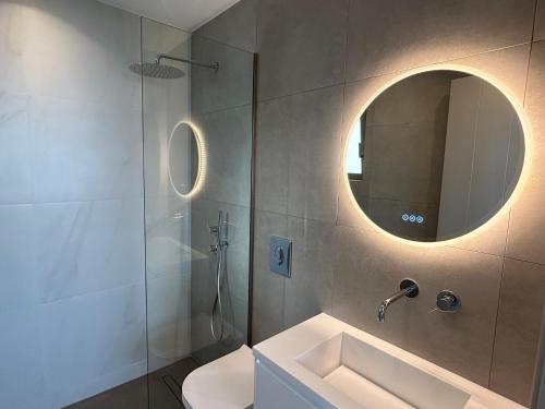 a bathroom with a shower and a sink and a mirror at Sterna Suites in Paralía Kímis