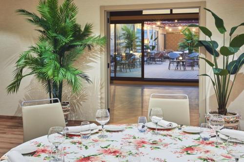 a table with chairs and a table with wine glasses at Hesperia Sevilla in Seville