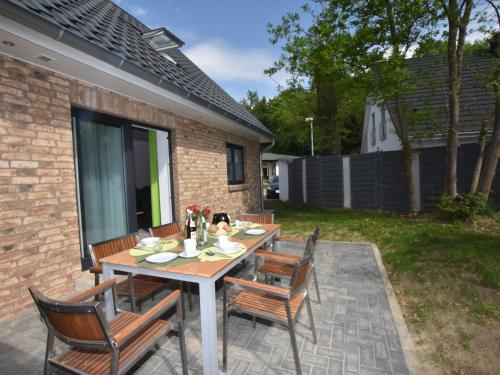 DamshagenにあるIdyllic Holiday Home in Damshagen with Terraceの木製テーブルと椅子付きのパティオ