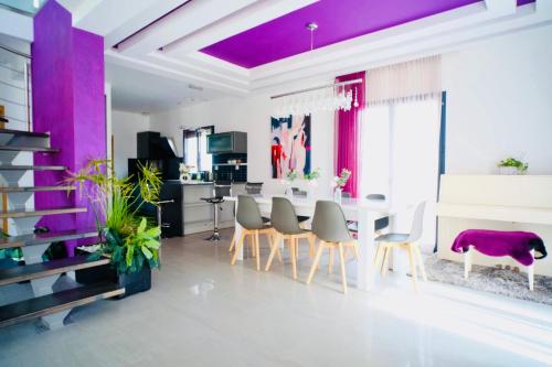 una sala da pranzo con pareti viola e tavolo e sedie di Villa Zara a Démouville
