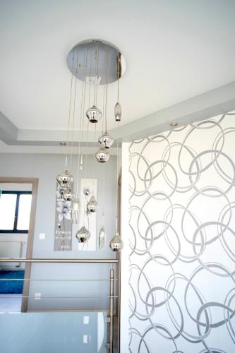 un lustre dans la salle à manger aux murs bleus dans l'établissement Villa Zara, à Démouville