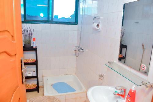 uma casa de banho com uma banheira, um lavatório e um WC. em Tranquil Retreat em Kigali