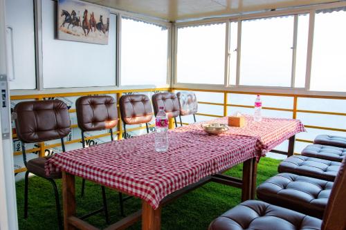 a dining room with a table and chairs and windows at Naya Gaun Eco Resort in Pokhara