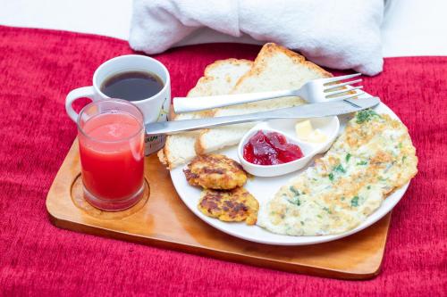 a plate of breakfast food with toast and a drink at Naya Gaun Eco Resort in Pokhara