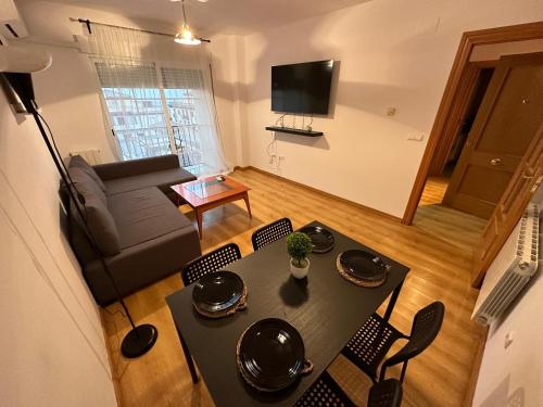 sala de estar con mesa, sillas y sofá en Bonito piso a solo 15 minutos de Granada en La Zubia