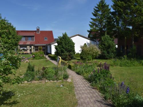 einen Garten mit einem Backsteinpfad vor einem Haus in der Unterkunft Beautiful Apartment in Robertsdorf with Garden in Blowatz