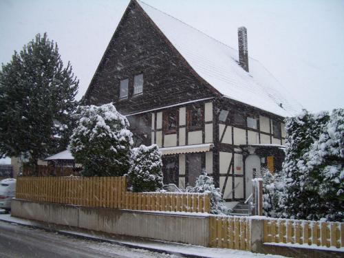 a house covered in snow with a fence at Cozy Apartment in L wensen Lower Saxony with Private Terrace in Bad Pyrmont