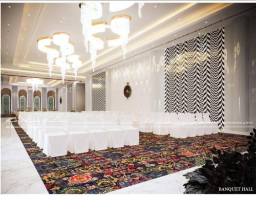 a large banquet hall with white tables and white chairs at Classic Sapphire Ananta Bundi in Būndi