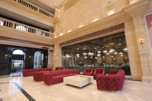 a lobby with red chairs and a table and a bar at Classic Sapphire Ananta Bundi in Būndi