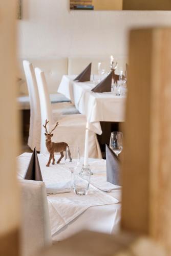 a table with wine glasses and a deer on it at Hotel Saliter Hof in Saalfelden am Steinernen Meer
