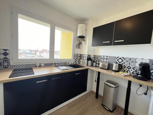 une cuisine avec un comptoir, un évier et une fenêtre dans l'établissement Le Phare, à Calais