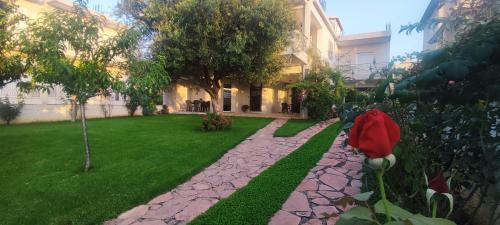 a garden with a red flower in a yard at “Villa Chrysa” luxury house in Flámbouras
