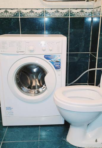 een badkamer met een wasmachine en een toilet bij г. Астана ЖК АПАТО in Zaozërnyy