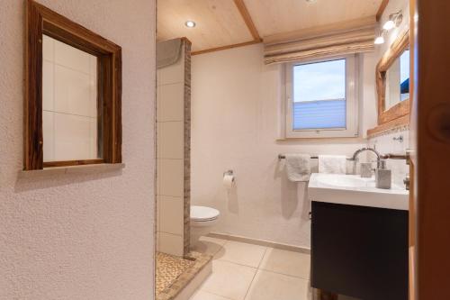 a bathroom with a sink and a toilet and a window at Jagahäusel Appartement Gitti in Jochberg