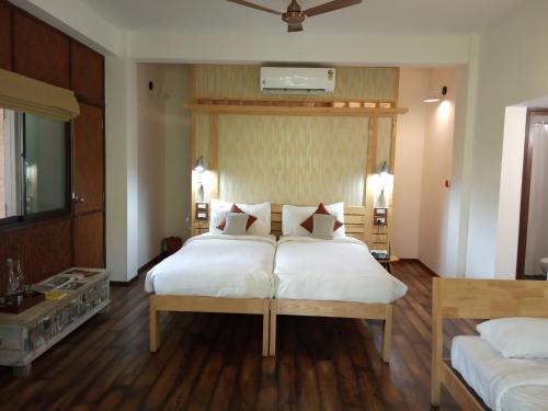 a bedroom with two beds with white sheets at Discovery Village Resorts in Begūr