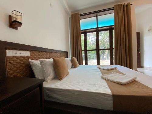a bedroom with a large bed with a window at Sharta Yala in Tissamaharama