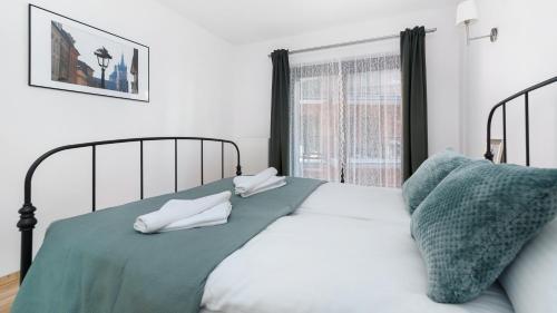 - une chambre avec un lit avec deux oreillers et une fenêtre dans l'établissement Apartamenty Sun & Snow Angel City, à Cracovie