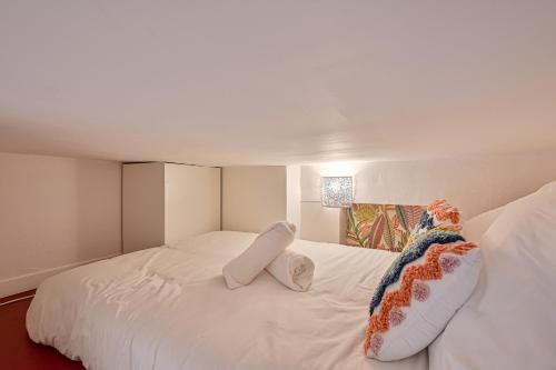 un lit blanc avec deux oreillers dessus dans l'établissement Le Saisonnier - Charme & Confort - Porte de Paris, à Saint-Ouen