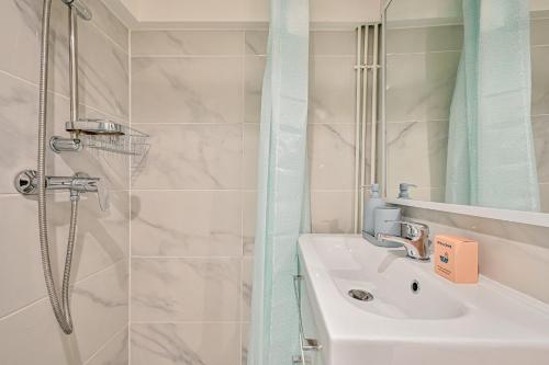 une salle de bain avec un lavabo et une douche dans l'établissement Le Saisonnier - Charme & Confort - Porte de Paris, à Saint-Ouen