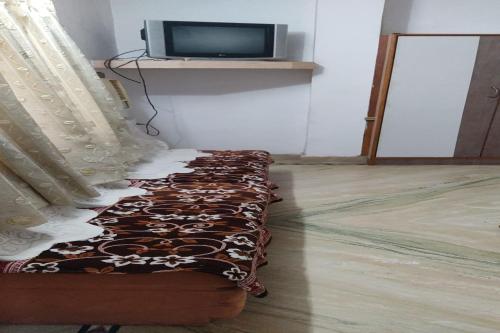 a couch with a curtain and a tv in a room at SPOT ON Hotal Manorath in Nāthdwāra