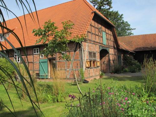 una antigua casa de ladrillo con techo naranja en Historic Farmhouse in Hohnebostel with Garden near Lake, en Langlingen